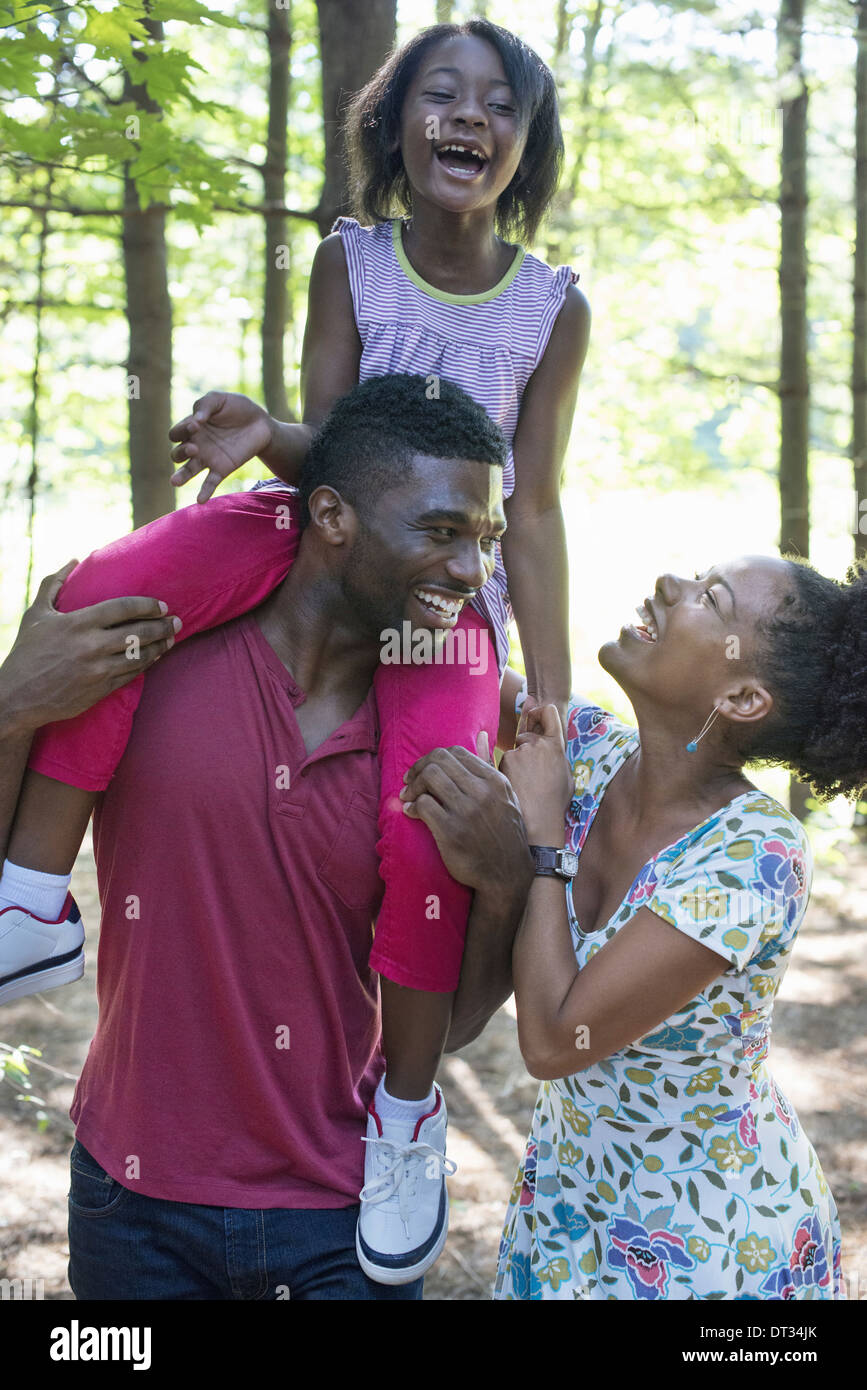 A family two parents and a child sitting on her father's shoulders