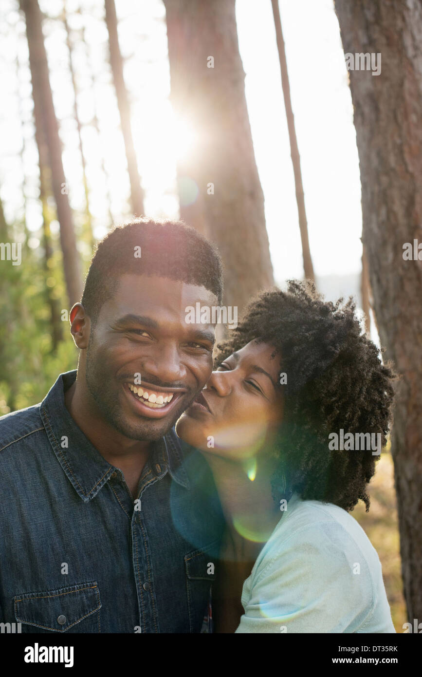 A couple a young woman kissing a man on the cheek Stock Photo