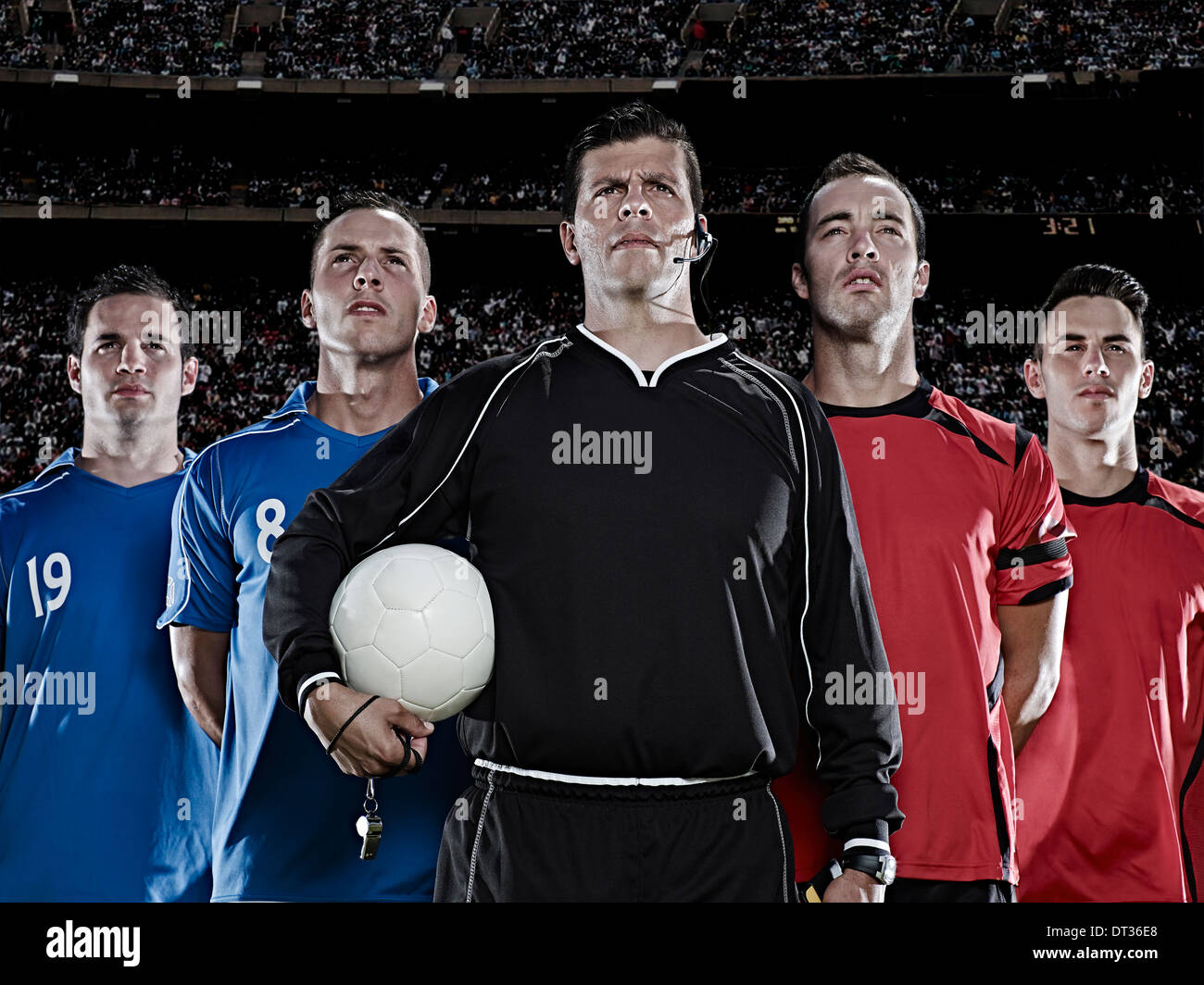 Soccer teams and referee standing in stadium Stock Photo
