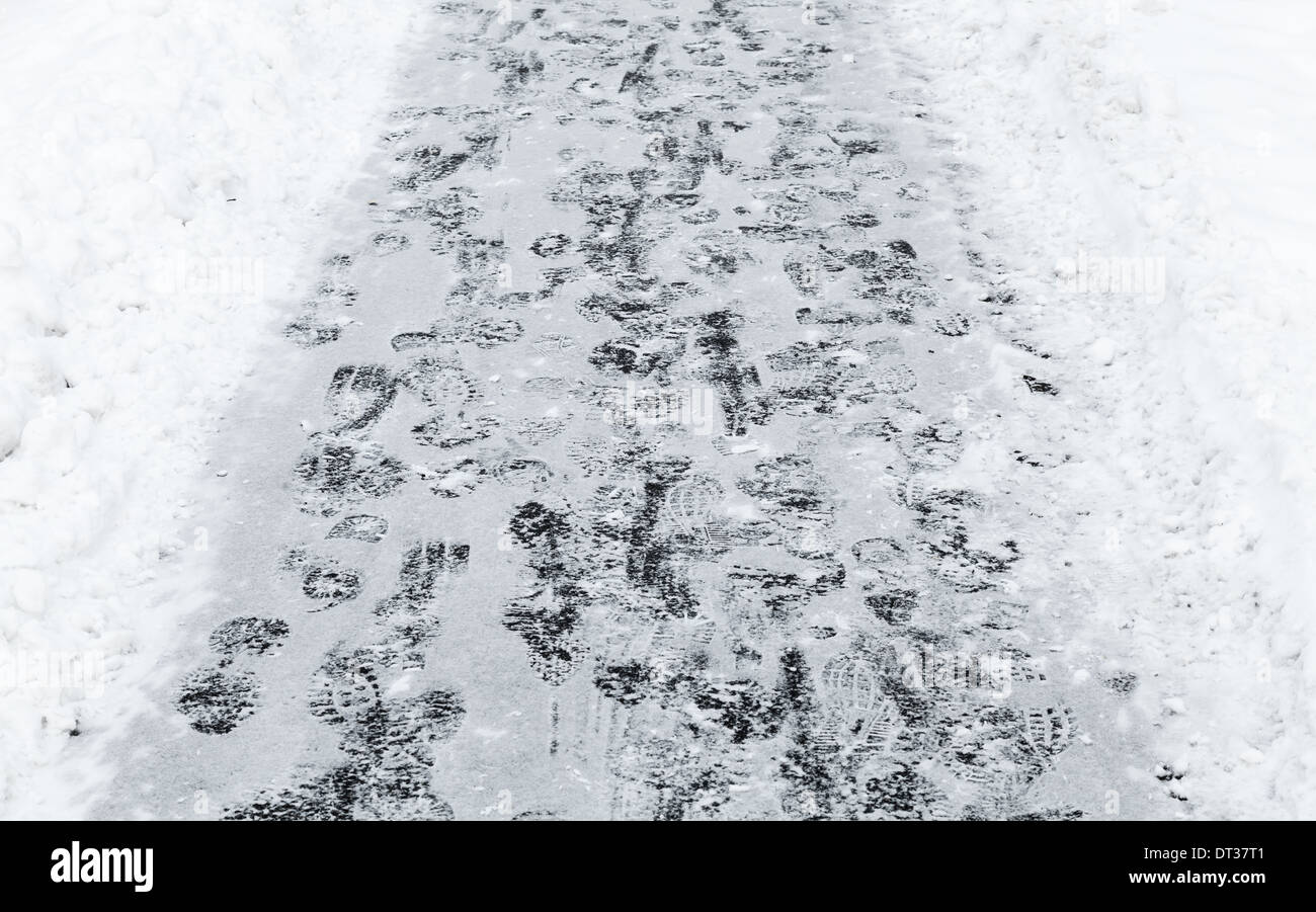 Frozen lane with footprints on snow in winter park Stock Photo
