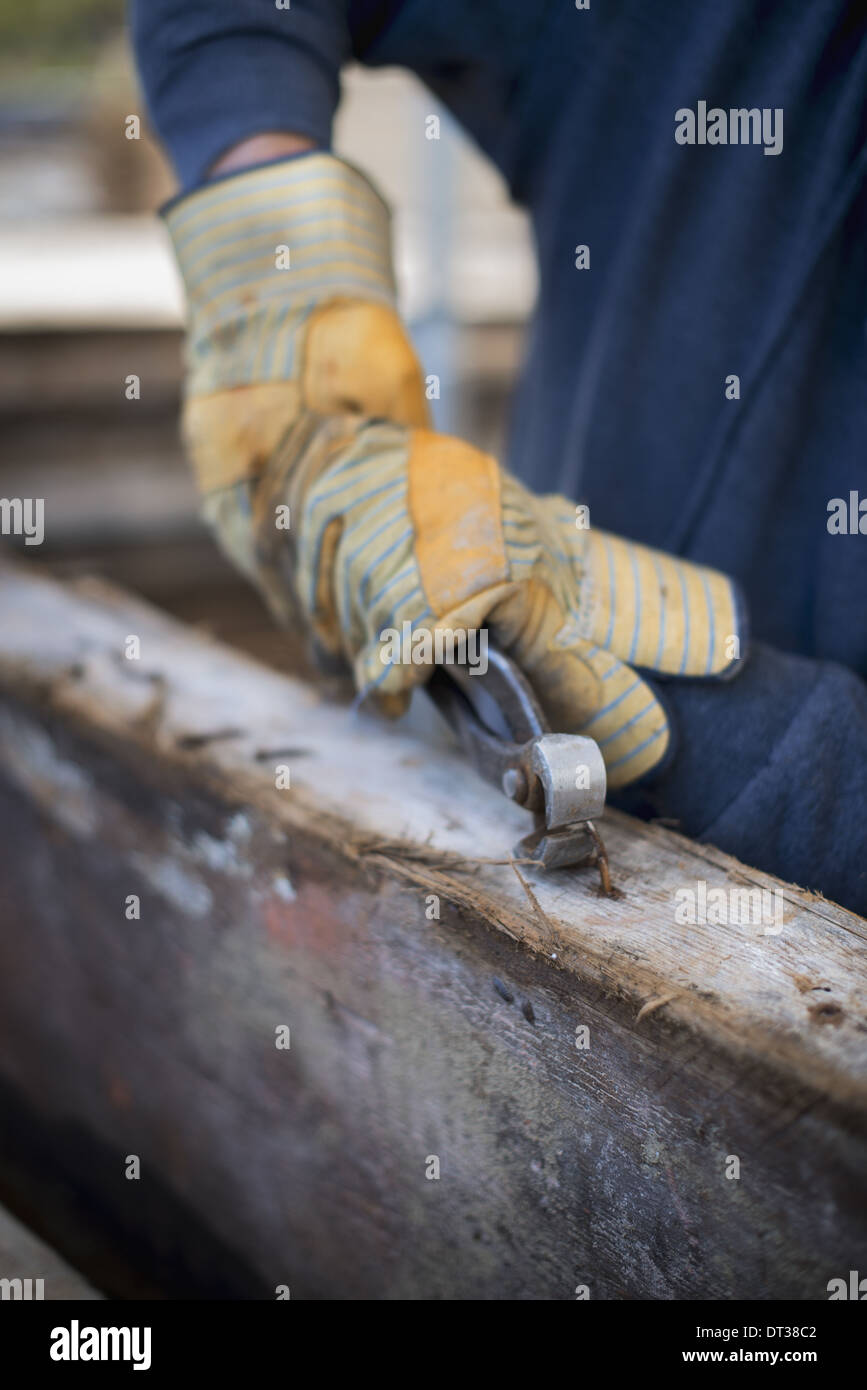 A reclaimed lumber A man preparing the timber by removing all