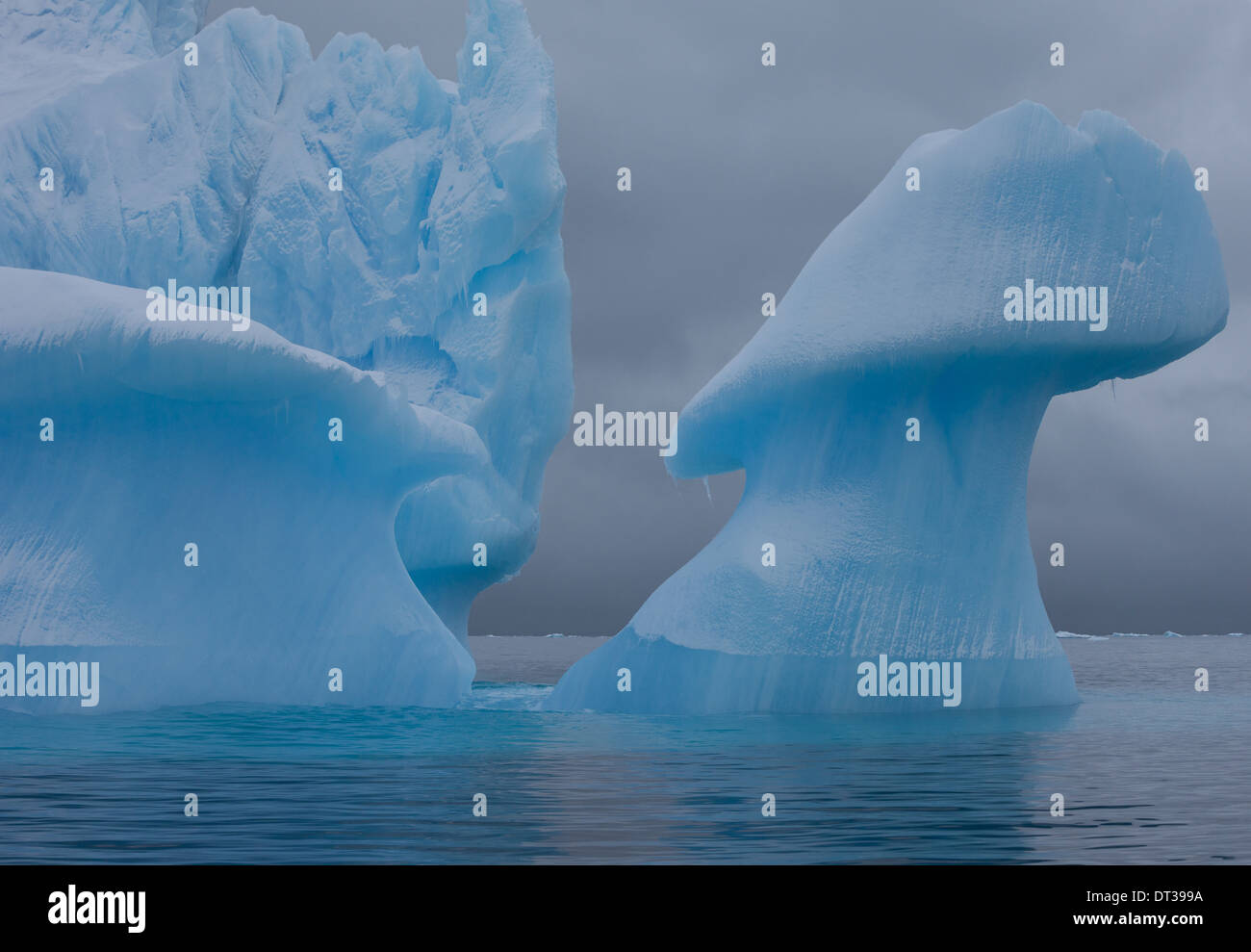 Icebergs with eroding and changing form drifting on the water, Antarctica Stock Photo