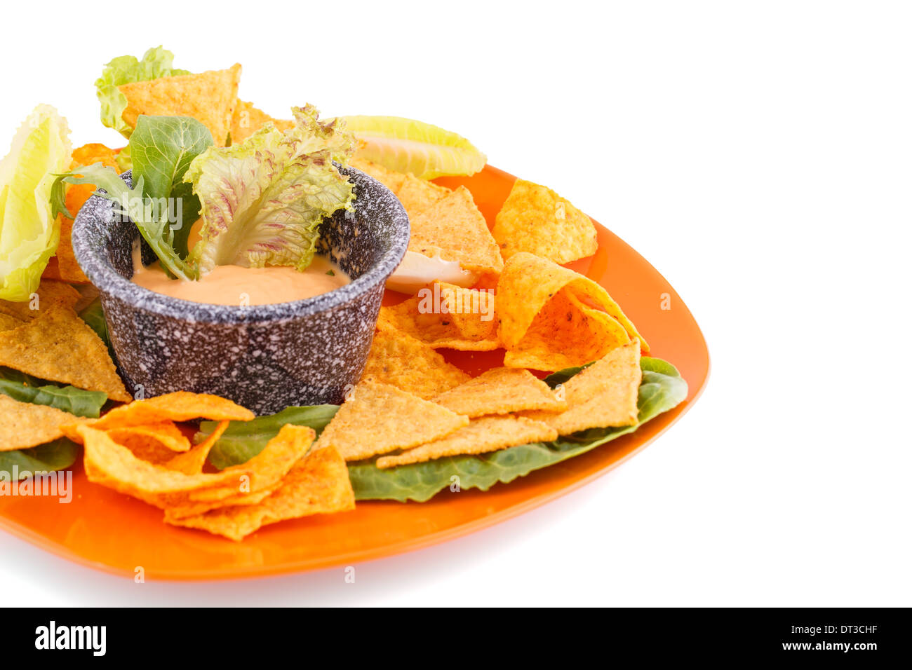 Nachos, lettuce and cheese sauce isolated on white background Stock