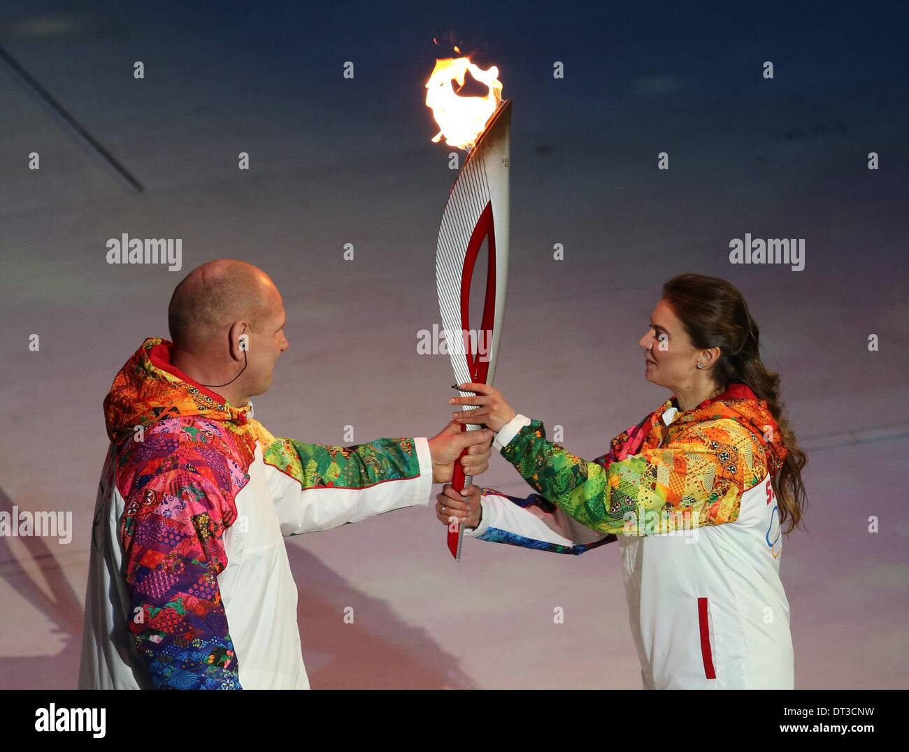 Sochi, Russia. 07 February 2014. Alexandr Karelin (L) receives the Olympic torch from Alina Kabaeva of Russia follow during the Opening Ceremony in Fisht Olympic Stadium at the Sochi 2014 Olympic Games, Sochi, Russia, 07 February 2014. Photo: Fredrik von Erichsen/dpa/Alamy Live News Stock Photo