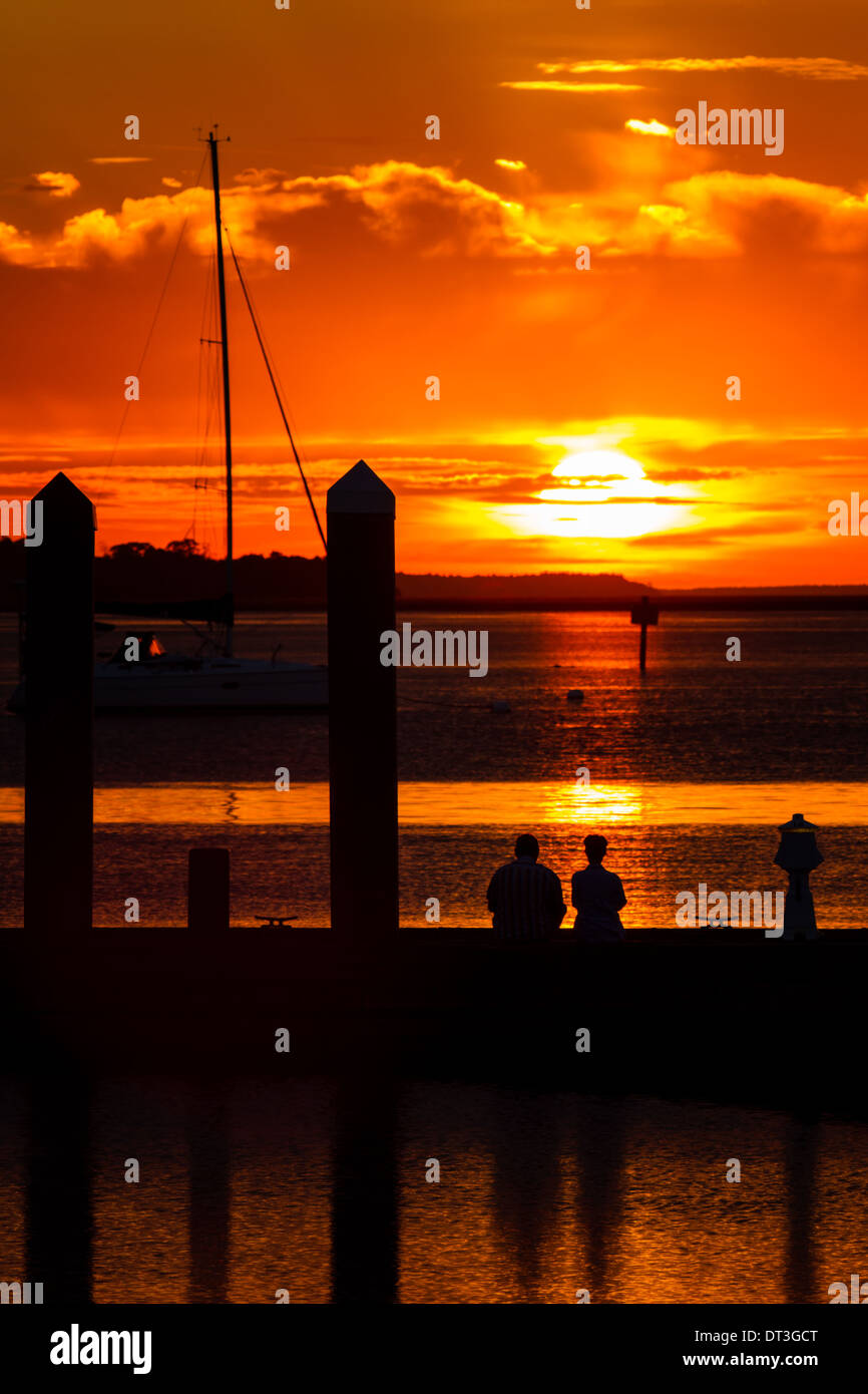 A couple watches the sun set at the Fernandina Beach Marina in Florida. Stock Photo