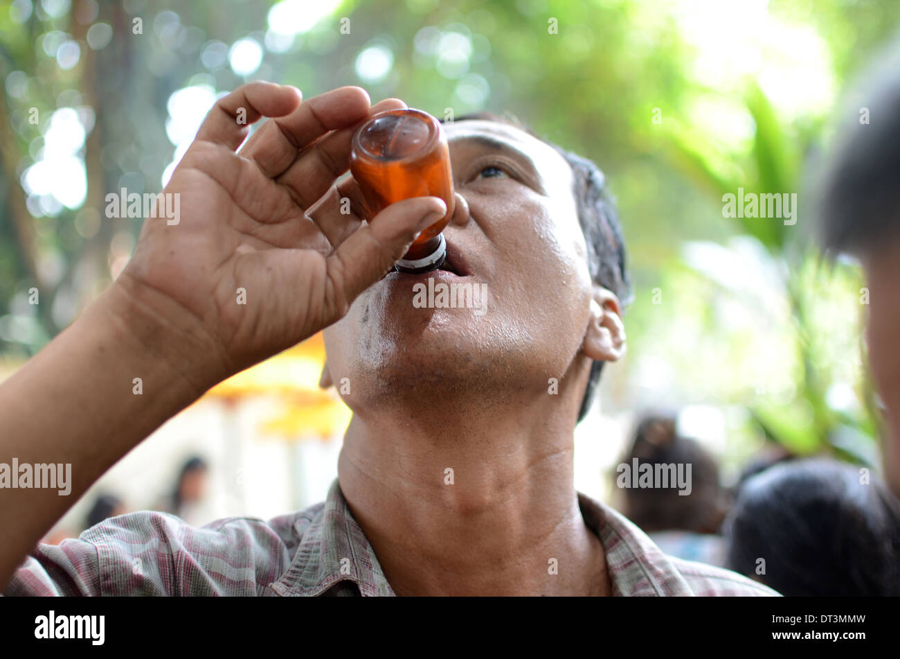 A man drinking traditional liquor called Badek in a ritual pilgrimage at the tomb of Prabu Anom in Doko village. Stock Photo