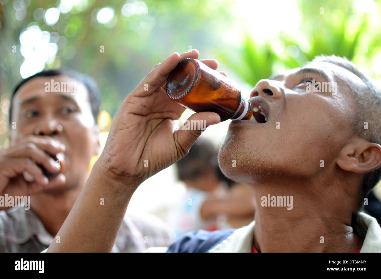 A man drinking traditional liquor called Badek in a ritual pilgrimage at the tomb of Prabu Anom in Doko village Stock Photo
