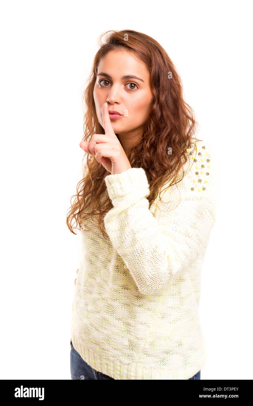 Beautiful woman with finger in front of her mouth asking for silence / less noise Stock Photo