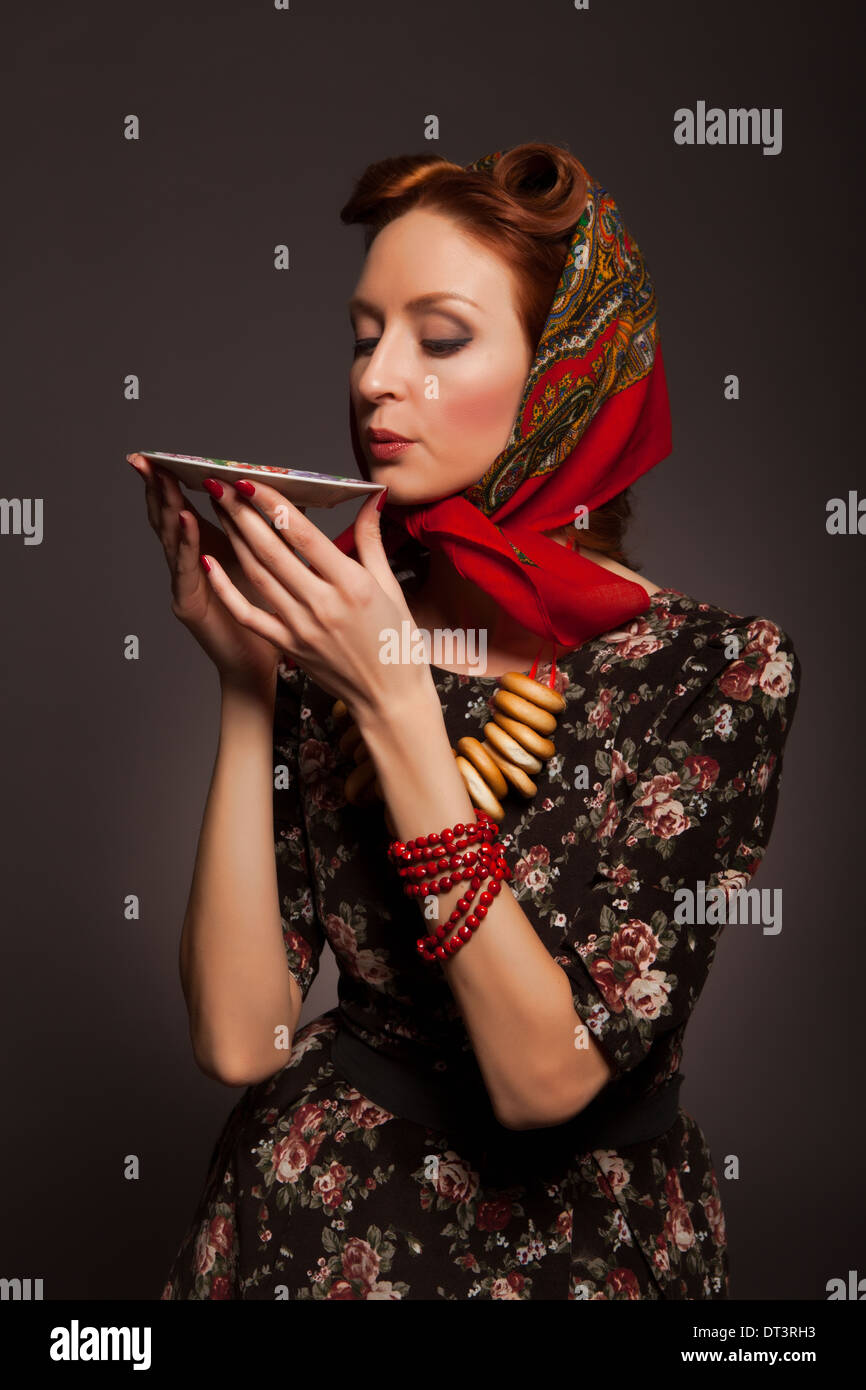 Girl in Russian style posing in red kerchief and bagels on the neck