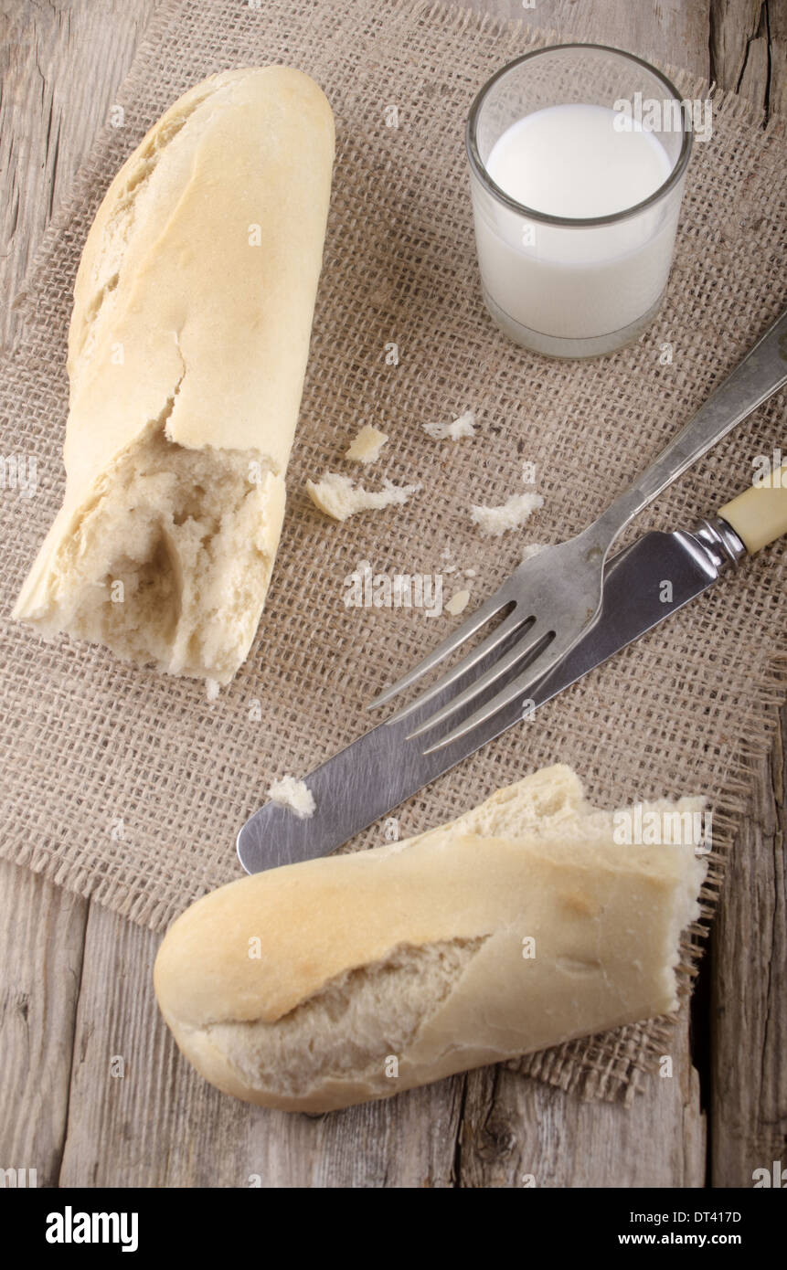 french bread on jute with fork, knife and glass milk Stock Photo Alamy