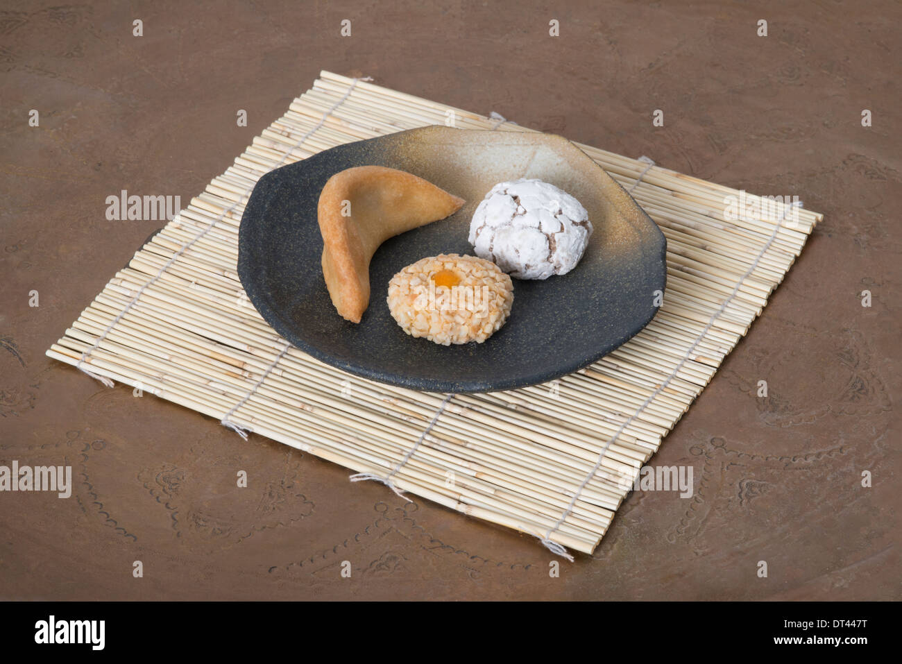 Moroccan pastry gazelle horns with sesame and ghribas on ceramic plate Stock Photo
