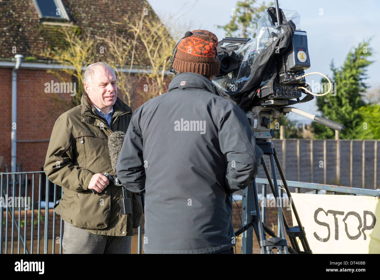 Burrowbridge, Somerset, UK. 8th February 2014. Conservative MP Mr Ian Liddell-Grainger being interviewed by BBC News on 8th February 2014 standing on the bridge over the River Parrett on the A361 at Burrowbridge, Somerset. Due to heavy rainfall, the rivers Parrett and Tone have burst their banks flooding nearby farmland and leaving houses underwater. Following visits by Lord Chris Smith and David Cameron yesterday, a severe flood alert remains and some occupants have been told to evacuate. The Somerset Levels have experienced the worst flooding in living history. Credit:  Nick Cable/Alamy Live Stock Photo
