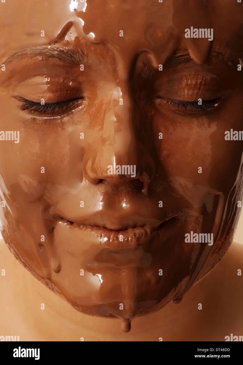 Girl with face covered in dripping chocolate. Stock Photo