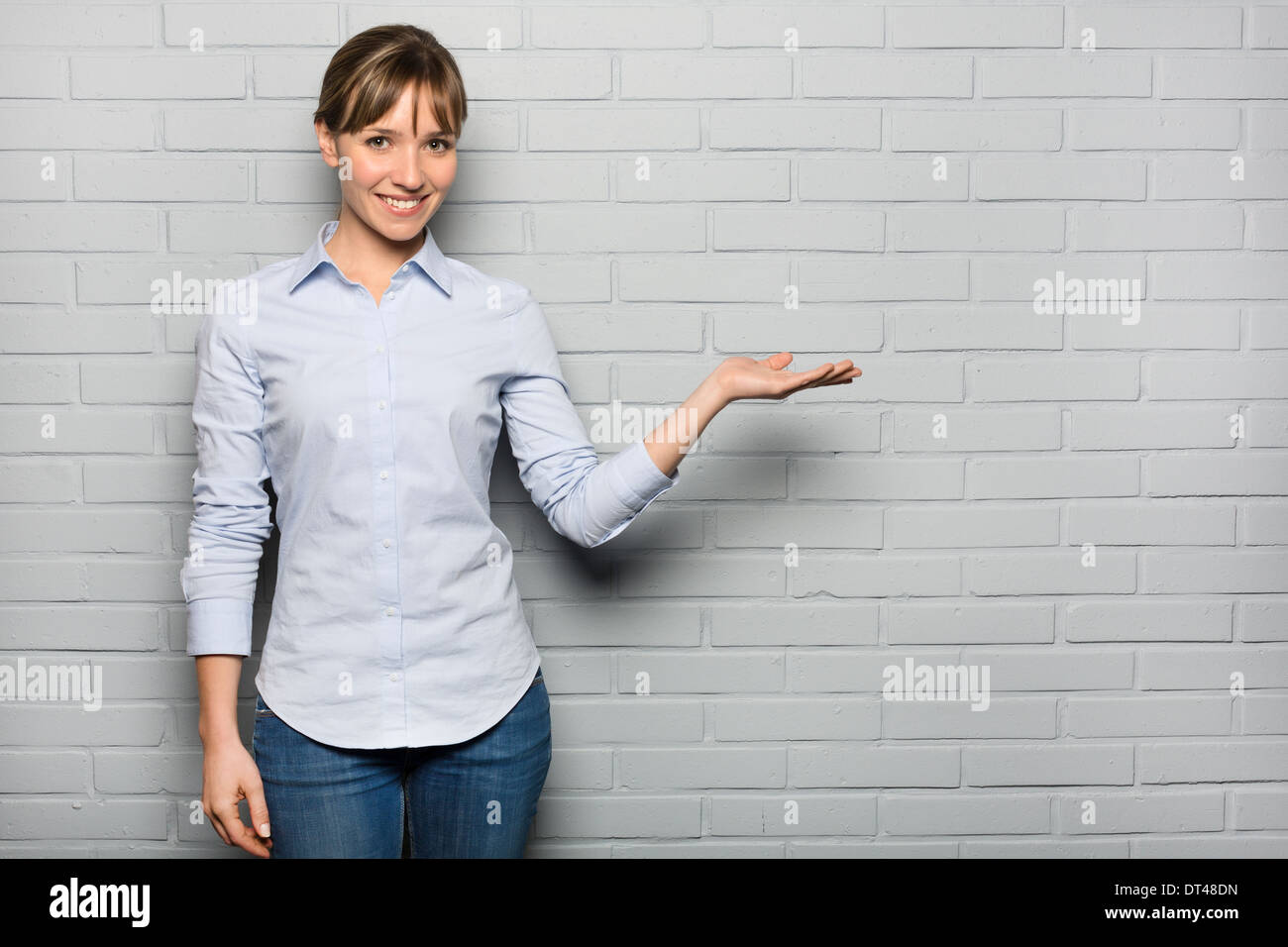 Female pretty cheerful pointing studio grey background Stock Photo