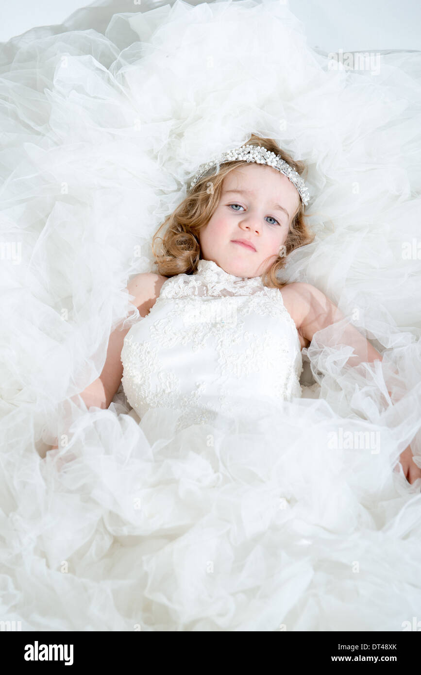 A Young Girl In An Adult S Wedding Dress Smiling And Happy Stock