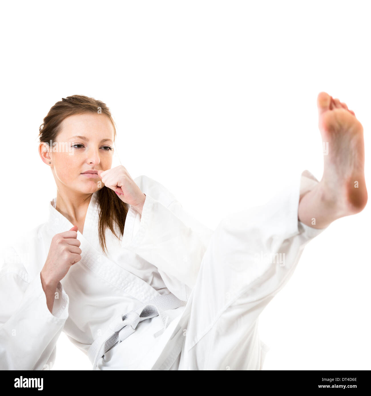 Beautiful caucasian, young, woman makes a kick in karate kimono on