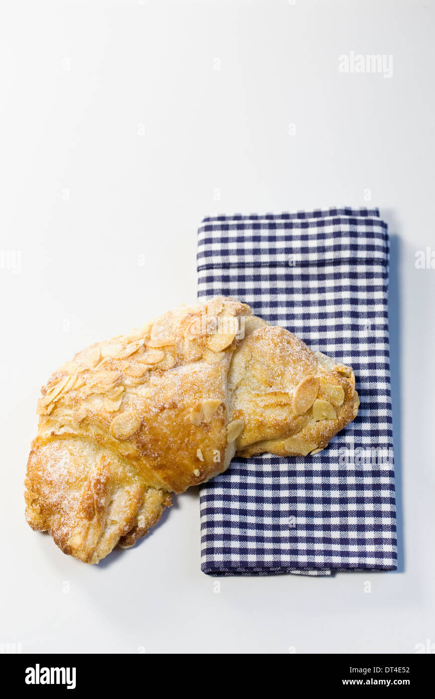 Almond croissant. Single crescent shaped french pastry. Stock Photo
