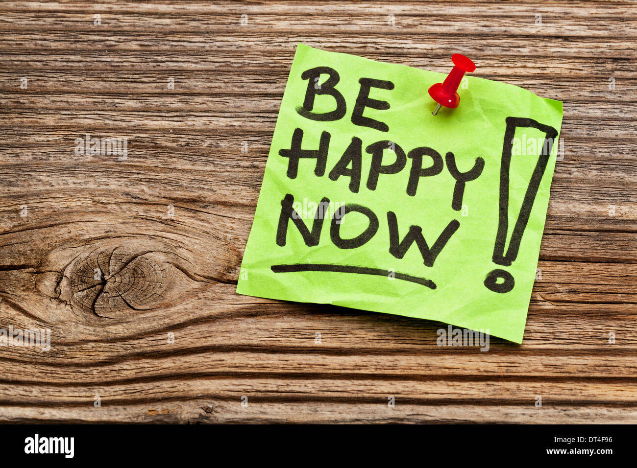 be happy now reminder note against grained weathered wood Stock Photo