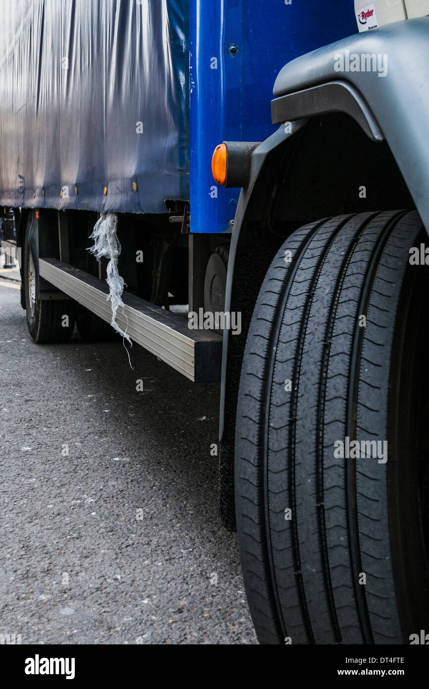 Closeup of a curtain sided delivery lorries front wheel and bodyside Stock Photo