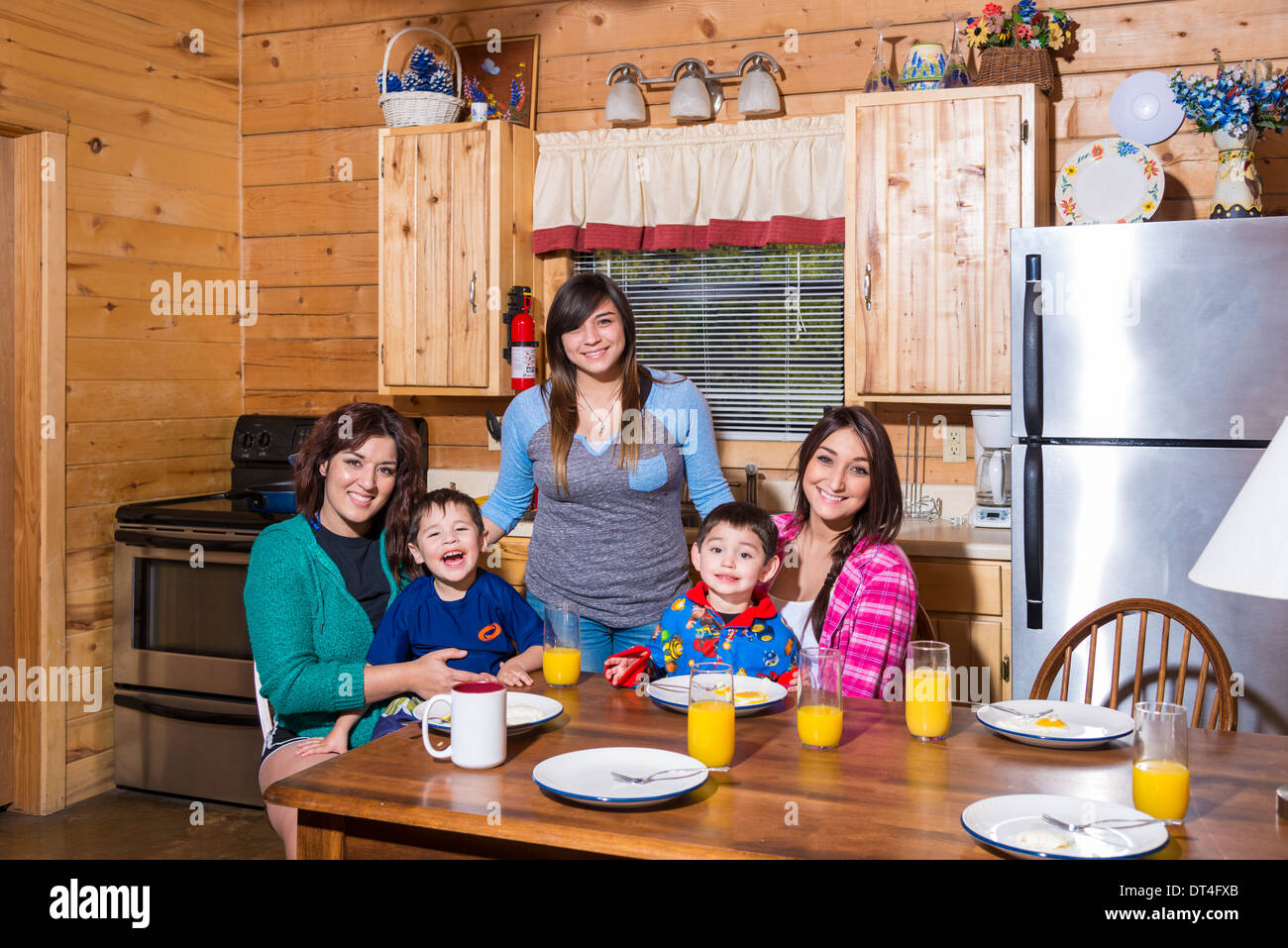 Family picture of 3 adult sisters with two children. The young boys are 3 years. All are of Hispanic ethnicity. Stock Photo