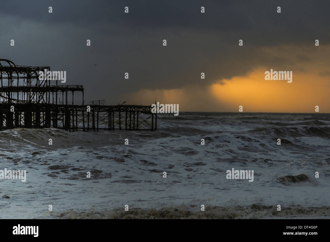 Brighton, UK. 8th Feb, 2014. Sky darkens as storms approach from the West. The old pier skeleton takes another battering. Credit:  David Burr/Alamy Live News Stock Photo
