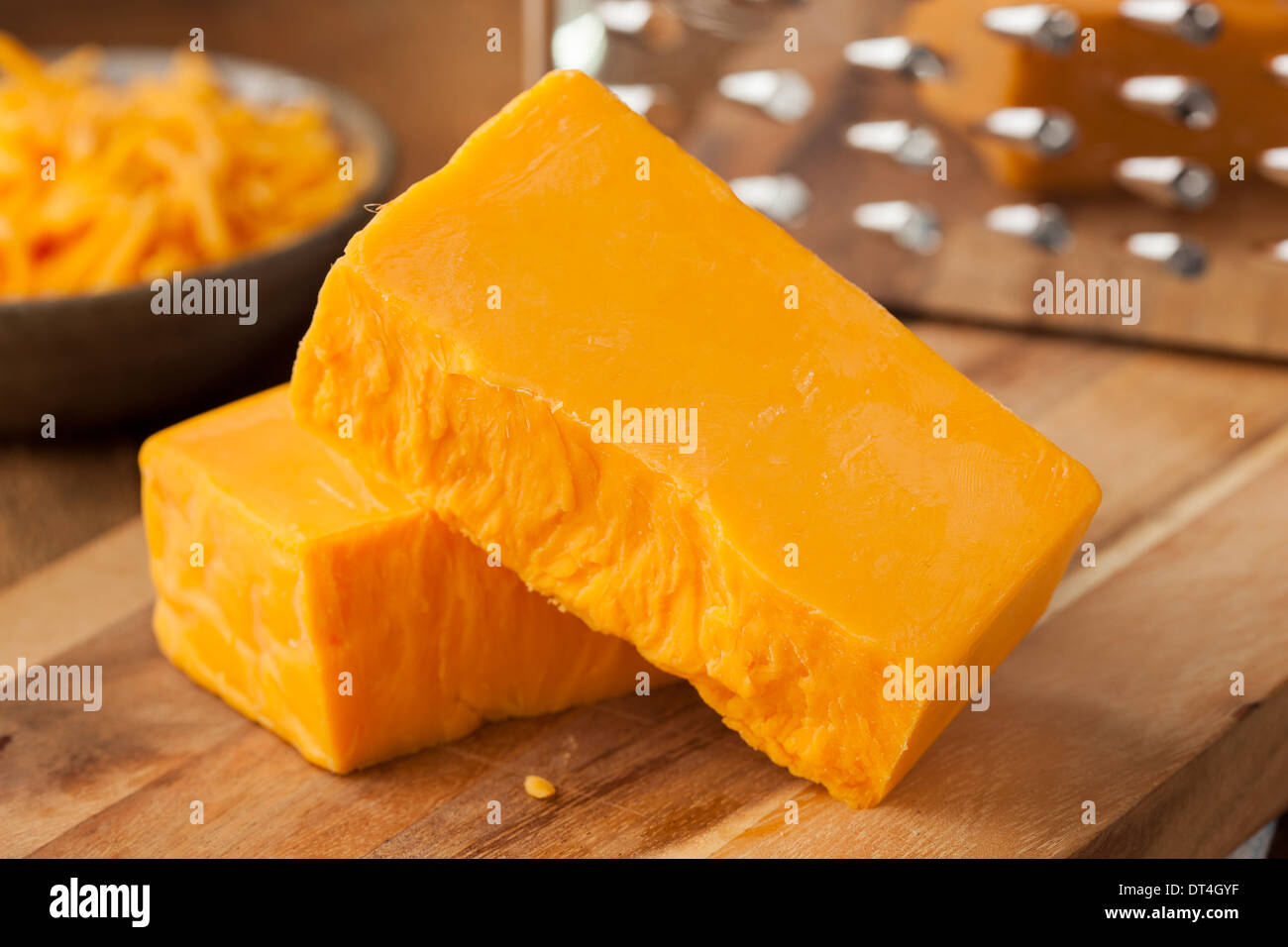 Organic Sharp Cheddar Cheese on a Cutting Board Stock Photo