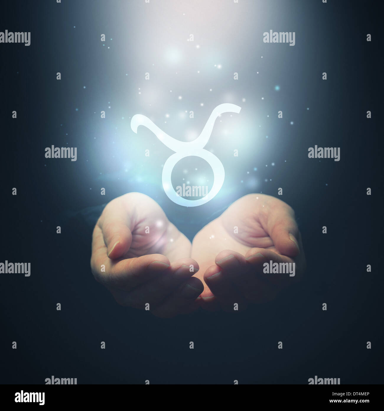 Female hands opening to light and holding zodiac sign for Taurus. Horoscope symbols. Selective focus. Stock Photo