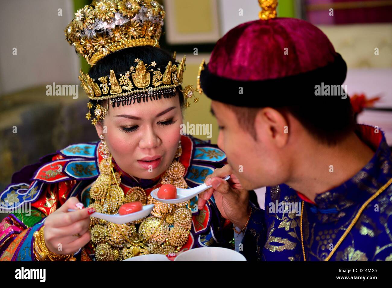 Melaka, Malaysia. 8th Feb, 2014. The bride and the groom feed 