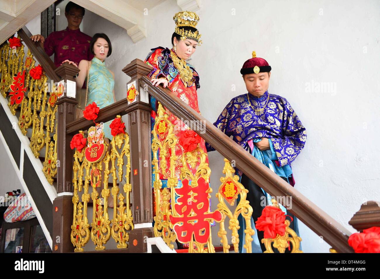Melaka, Malaysia. 8th Feb, 2014. The groom guides his bride out of 