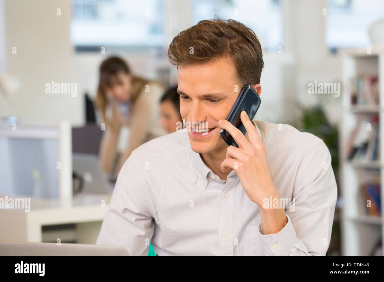 Man Cheerful desk cell phone young Stock Photo