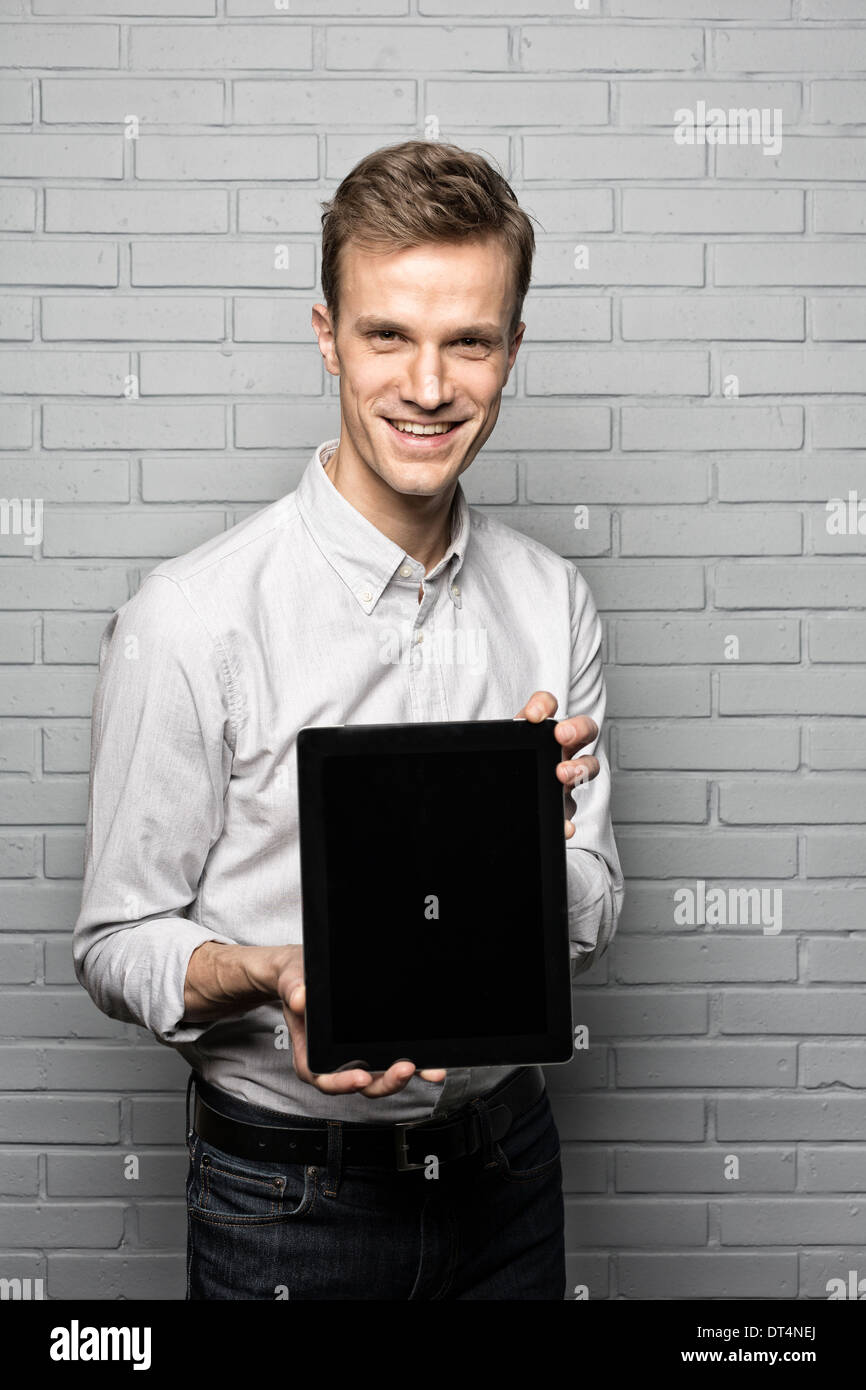 Male portrait smiling digital tablet studio brick looking camera Stock Photo
