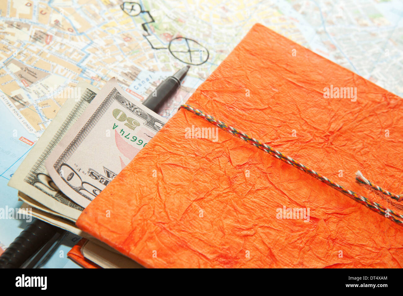 Close-up Travel Arrangement of Dollars, Map and notepad diary Stock Photo