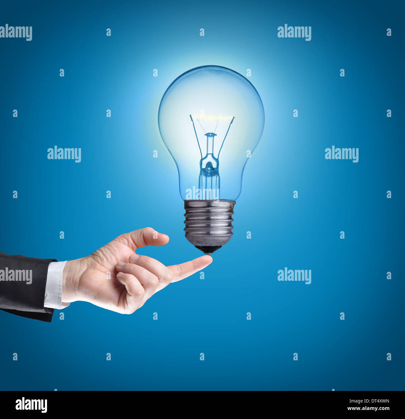 Light bulb on tip of finger on businessman.Blue background Stock Photo ...