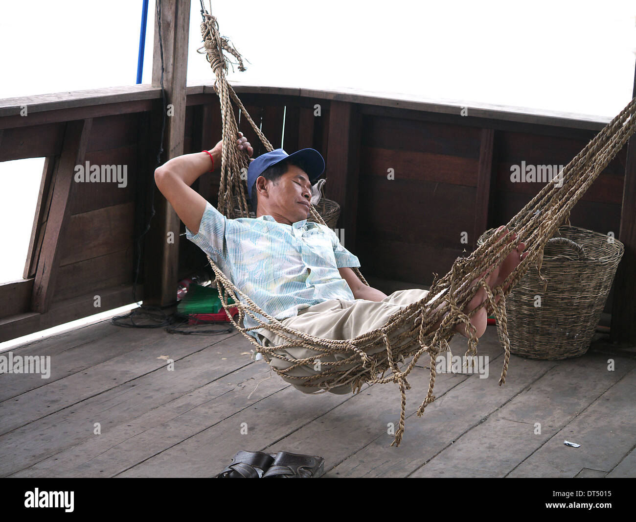 Man in hammock on boat asleep in Cambodia Stock Photo