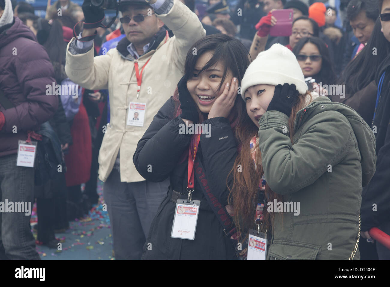 Teenage girls hold their ears at the Chinese New Year firecracker ceremony in NYC. Stock Photo