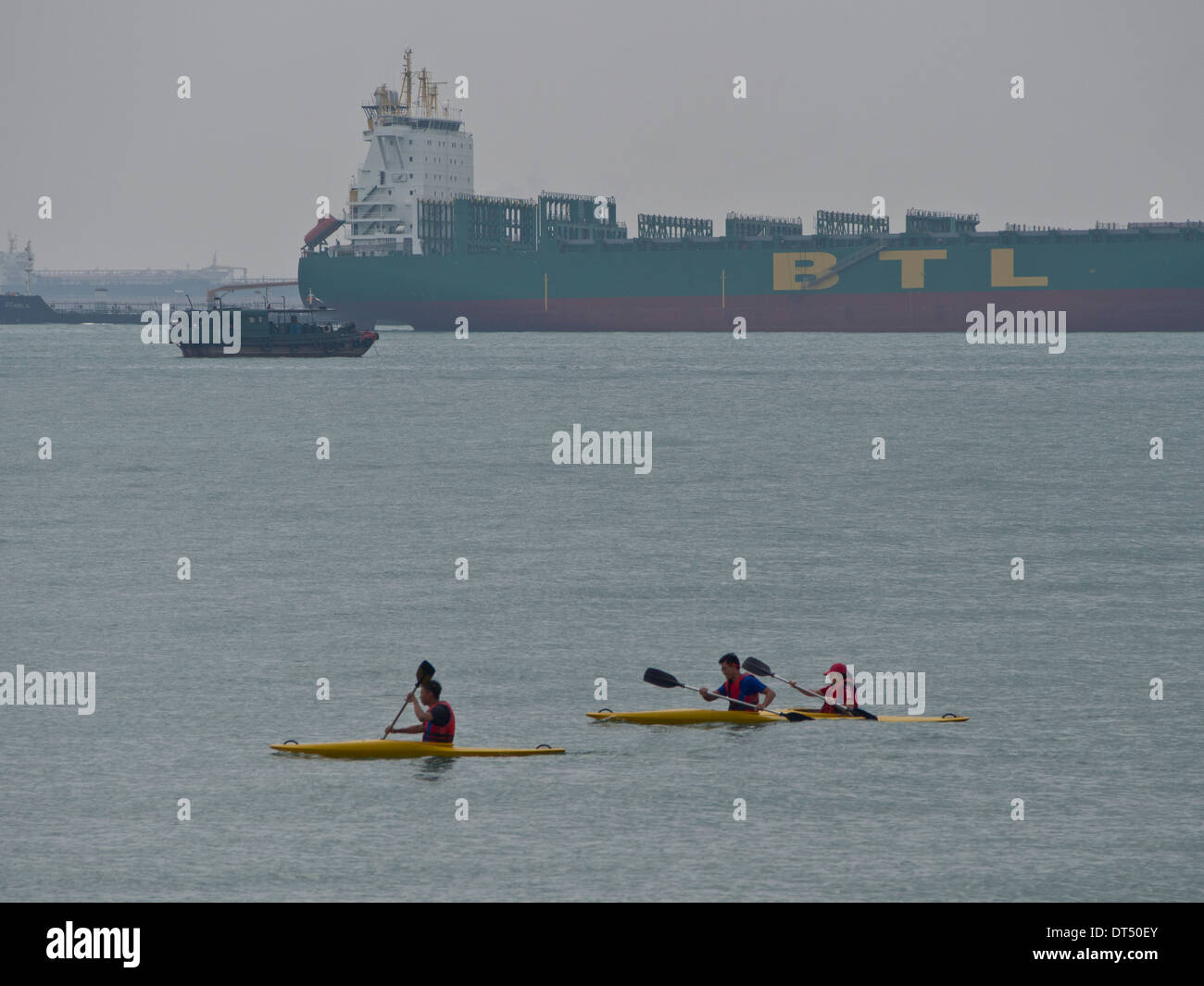 People kayaking with cargo ships in background at the East Coast Park, Singapore Stock Photo Alamy
