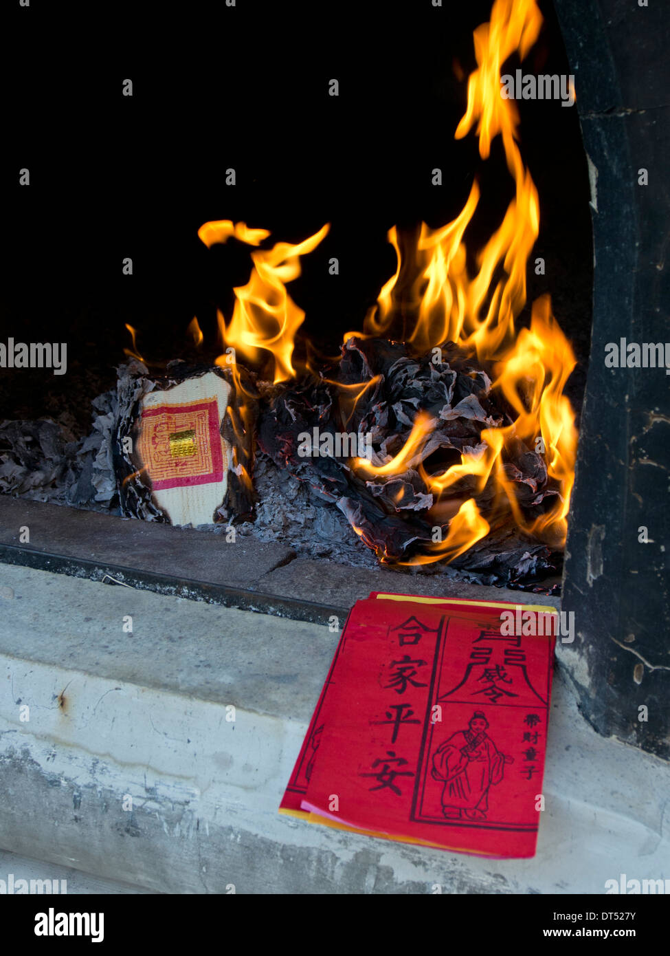 Burning paper money at a temple on the eve of Chinese New Year in Singapore Stock Photo