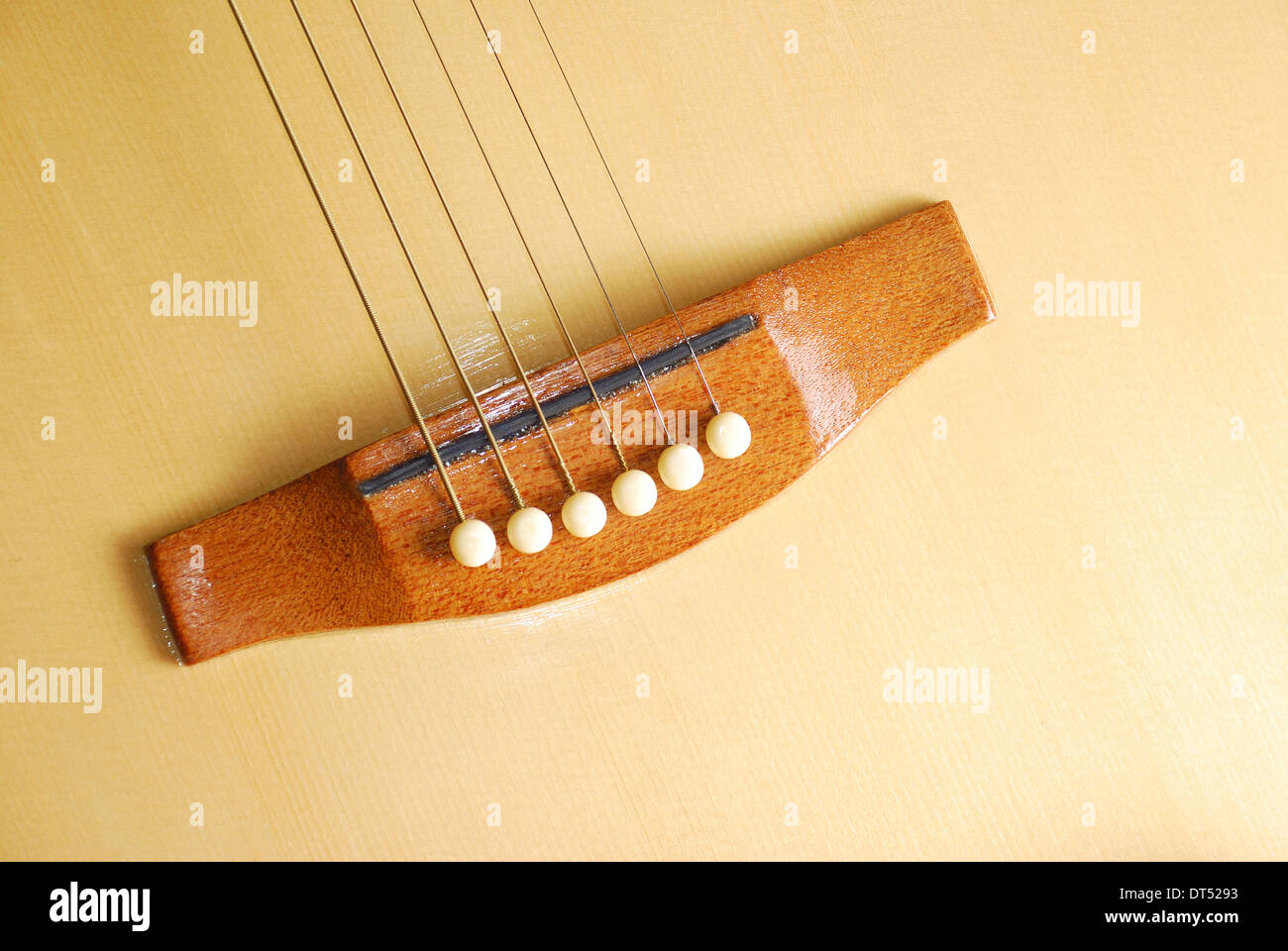 Six-string acoustic guitar focused in the area of the guitar's bridge Stock Photo