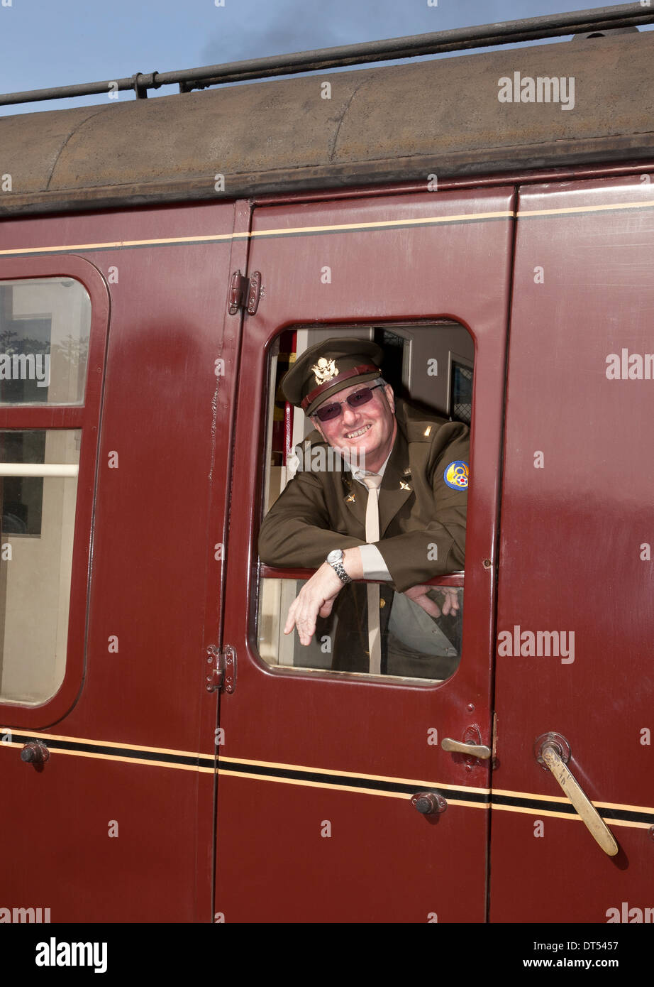 A man leaning out of a train window in 1940's Military uniform Stock Photo