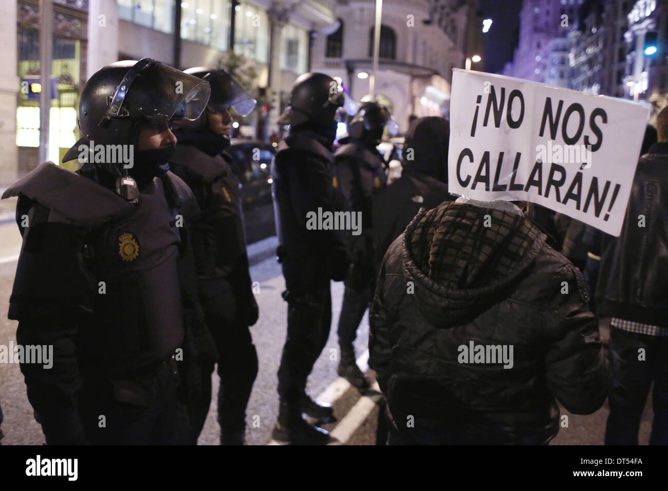 Madrid, Spain. 8th Feb, 2014. Police in riot gear looks at a protestor ...