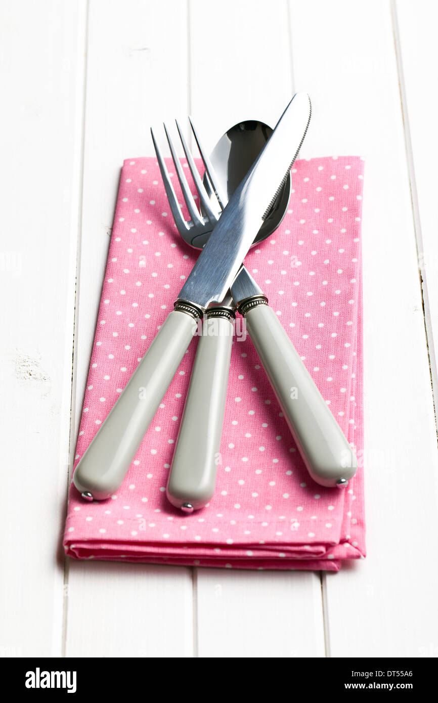 cutlery on napkin on wooden table Stock Photo