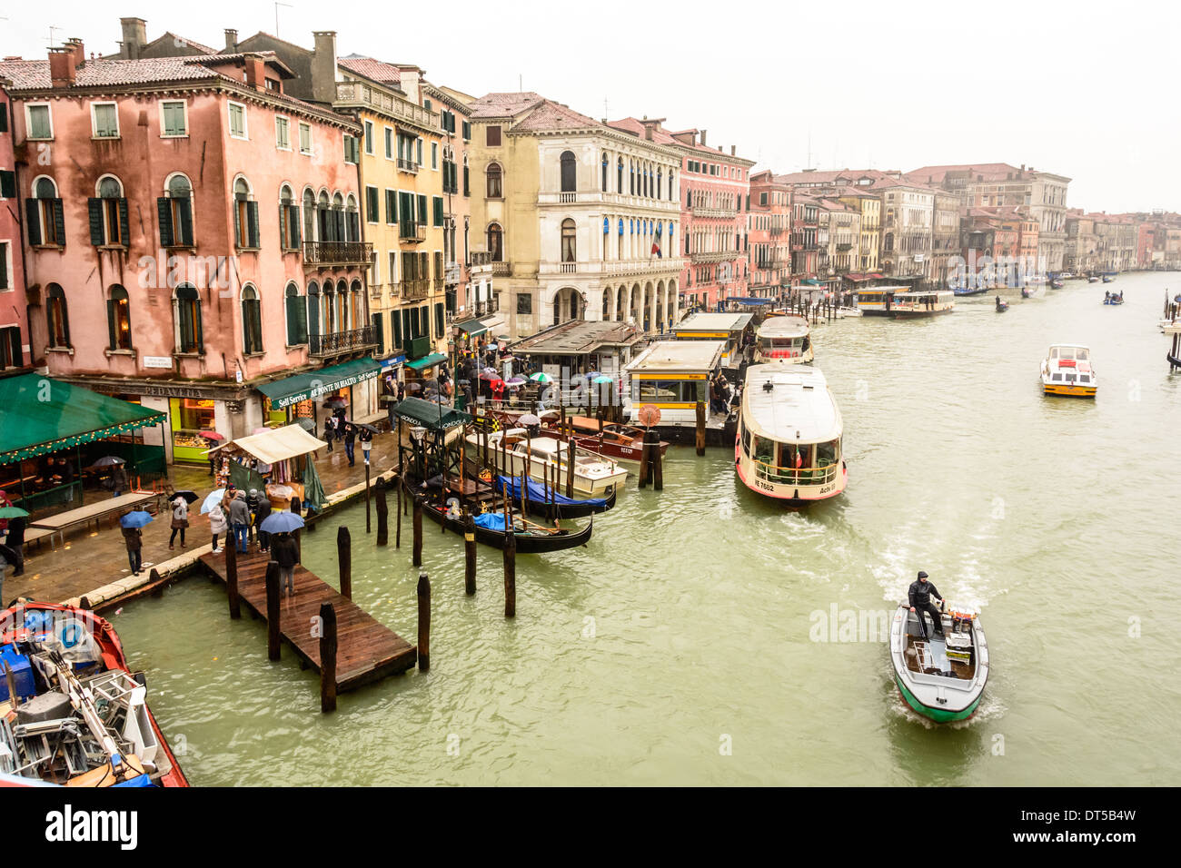 Venice, Italy. View from Rialto Bridge over the Grand Canal and the Rialto waterbus station at an overcast rainy day. Stock Photo