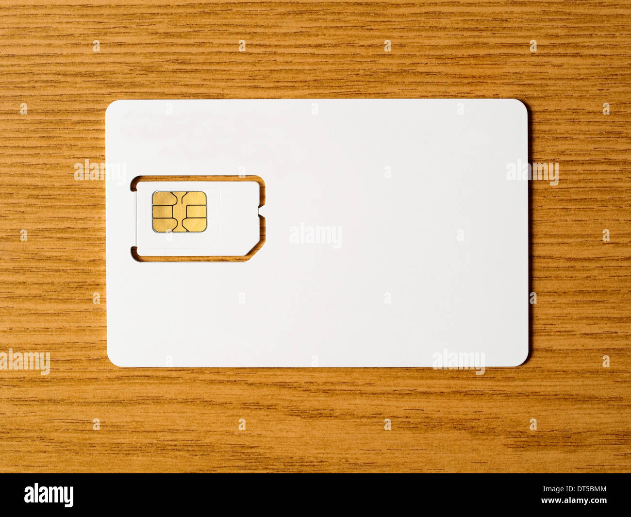 Blank SIM card on wooden surface, ready for your customization Stock Photo
