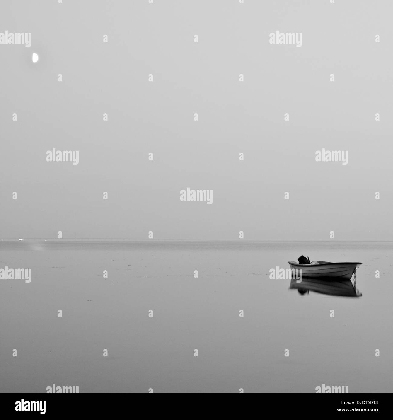 A black and white photo of a lonely boat moored offshore Bjärred, Sweden. Stock Photo