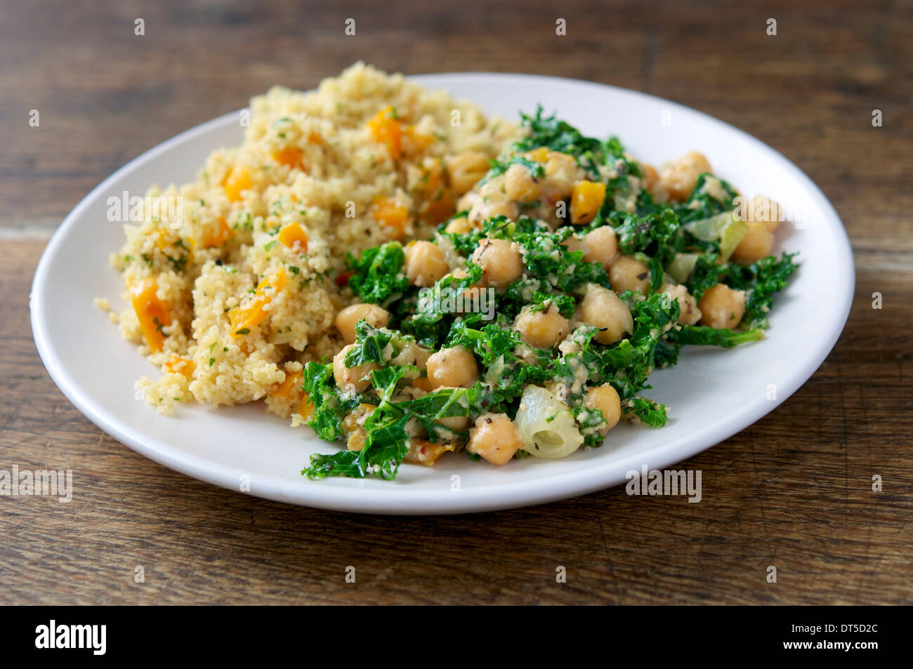A hearty and filling meal with kale, cashew and chickpeas, served with confetti couscous. Stock Photo