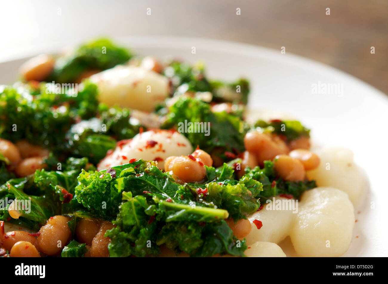 This recipe with gnocchi, fresh kale and white beans makes a very hearty and filling winter meal. Stock Photo