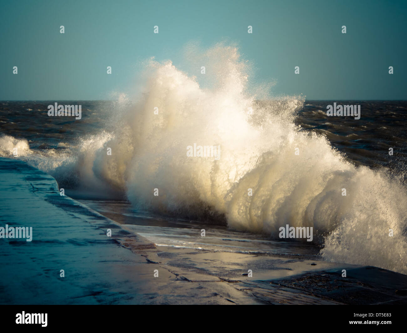 Waves break against a harbour wall in Southsea, Portsmouth Stock Photo