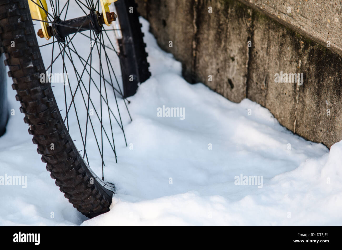 Bicycle wheel half buried in snow Stock Photo