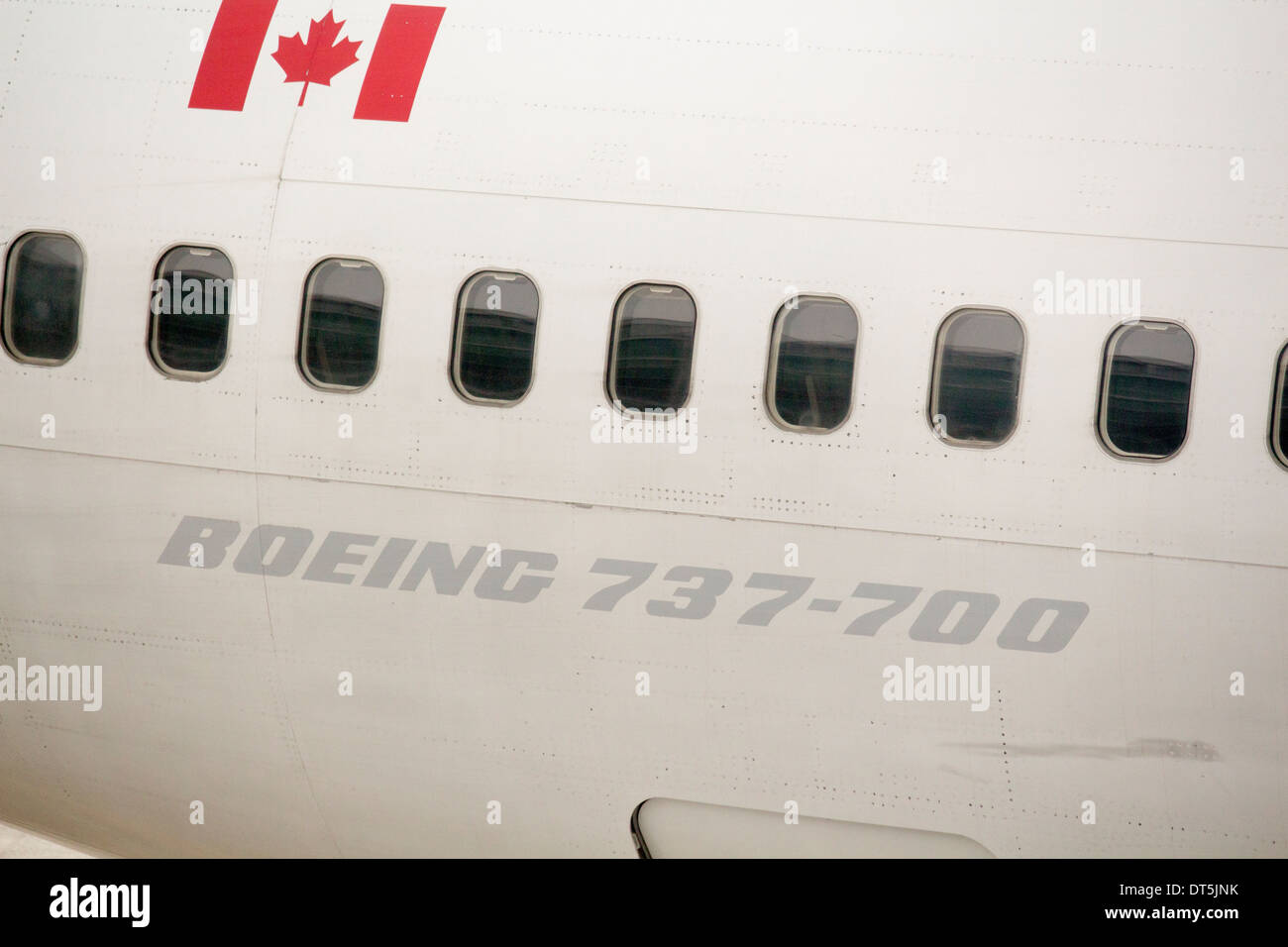 Side of Boeing 737 - 700 with Canadian flag above the windows Stock Photo