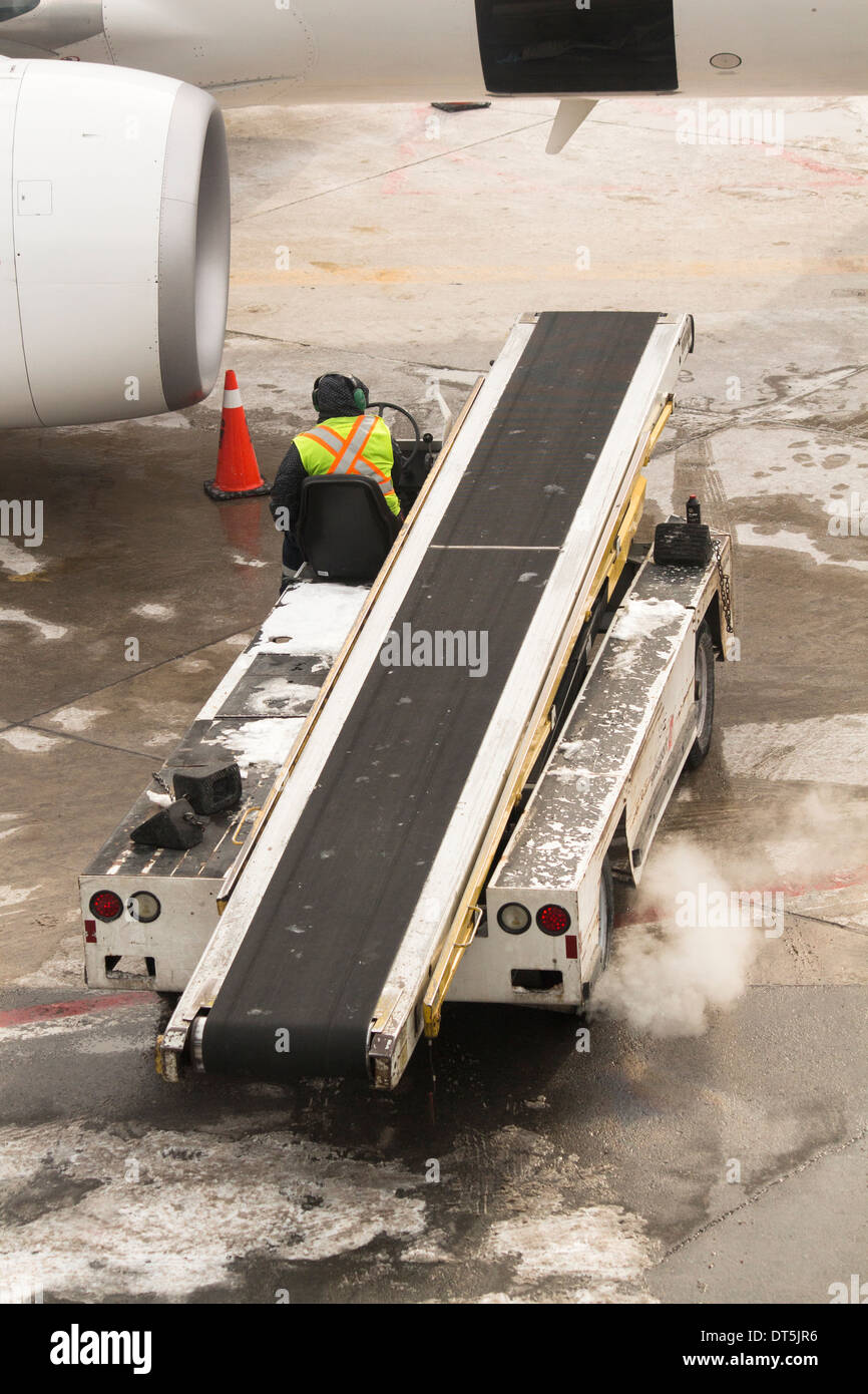 Man driving luggage conveyor truck to plane on tarmac at Pearson